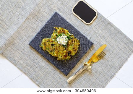 Roesti. Potatoes Grated With Greens, Fried In Butter. Serve On A Stone Board With Sour Cream, Garlic