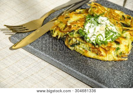 Roesti. Potatoes Grated With Greens, Fried In Butter. Serve On A Stone Board With Sour Cream, Garlic