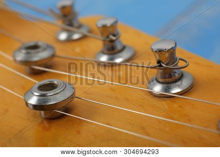 Musical Instrument - Fragment Headstock Peghead Neck Tuning Peg Electric Guitar On A Blue Wood Backg