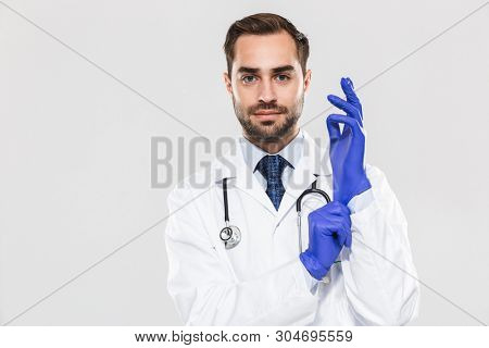Portrait of caucasian young medical doctor working in hospital and wearing disposable sterile gloves isolated over white background