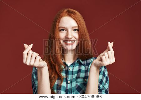 Speading Love And Happiness. Redhead Girl Showing Heart Sign