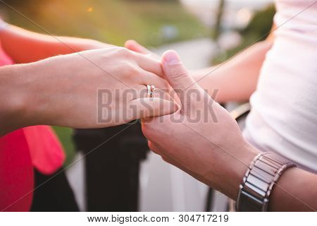 Young Man Giving Engagement Ring To His Girlfriend. Man Making Marriage Proposal To His Beloved Woma