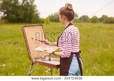 Back View Of Young Woman Artist Standing In Front Of Sketchbook With Brush And Palette Of Colours, P