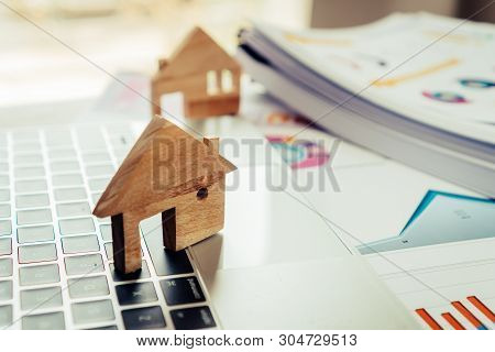 Property Real Estate Mortgage Loan Or Investment Concept: Wooden Home Model On Computer With Chart R