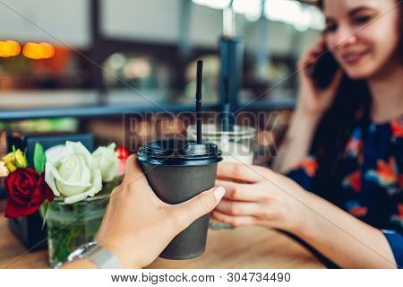 Women Friends Having Coffee In Cafe. Girld Toast With Paper Cup And Glass