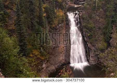 A Distant View Of A Majestic Waterfall In Monkman Provincial Park, Canada, The Torrent Of Water Sque