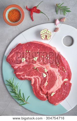 Raw Steak. Meat With Spices And Herbs. Top View On Light Stone Background.