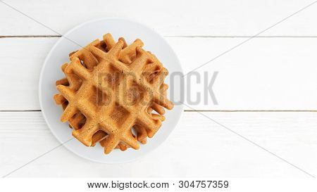 Stack Of Homemade Soft Belgian Waffles On White Wooden Table. Top View. Copyspace.