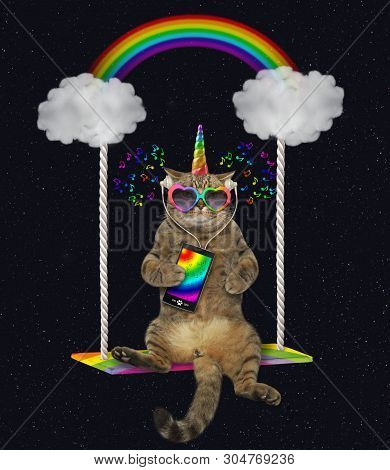 The Cat Unicorn In Sunglasses With A Smartphone And Headphones Is Listening To Music And Riding On T