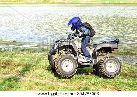 The Boy Is Traveling On An Atv.
