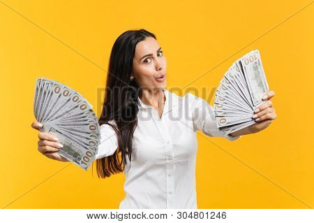 Portrait Of Amazed Young Woman In White Casual Shirt Holding Fan Of Cash Money In Dollar Banknotes I