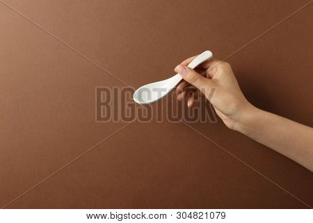 Woman Holding Empty Miso Soup Spoon On Color Background, Closeup. Space For Text