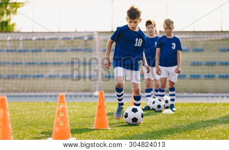 Soccer Camp For Kids. Boys Practice Dribbling In A Field. Players Develop Good Soccer Dribbling Skil
