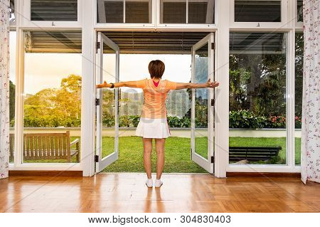 Women Enjoy Refreshing Sunrise With Greenaries Scene From Glass Door Home Interior In Tropical Highl