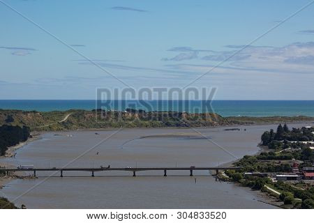 A Long Concrete Bridge Spanning The Estuary To The Ocean
