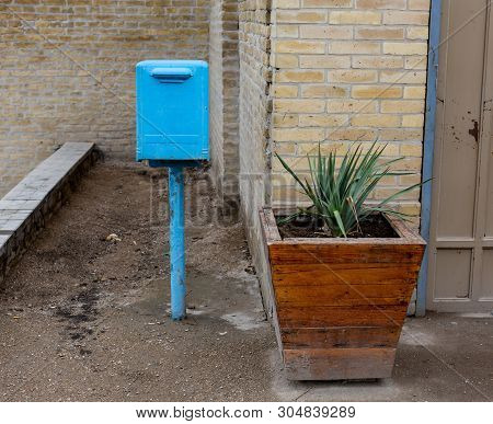 Blue Mailbox In Brisbane Australia With Hole Cut In Fence For Retrieving Mail