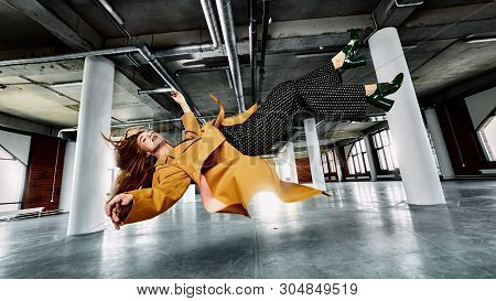 Young Woman Wearing Casual Clothes Lingering In Air In Relaxed State In Underground Parking