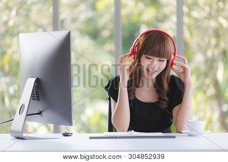 Young Beautiful Asian Office Staff In Black Dress Sitting At Working Desk Enjoy Nice Music With Red 