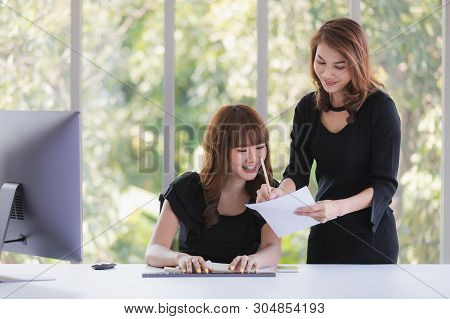 Portrait Of Two Beautiful Asian Successful Businesswomen In Black Dresses Busily Working In Modern O