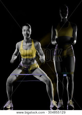 one mixed race woman exercising fitness exercises isolated on black background with lightpainting effect multiple exposures