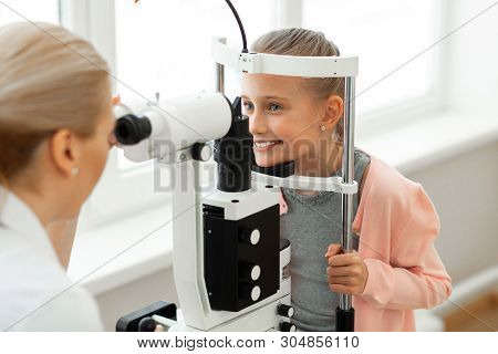 Pretty Good-looking Little Girl Placing Her Head On A Black Stand