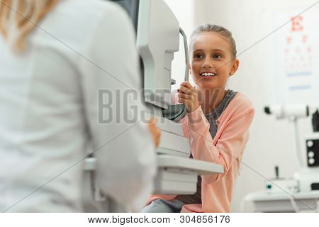 Appealing Little Girl With Blue Eyes Carrying Stands On Special Device