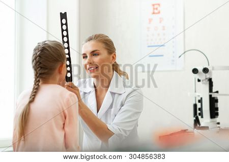 Kind Long-haired Oculist Using Long Tools With Holes