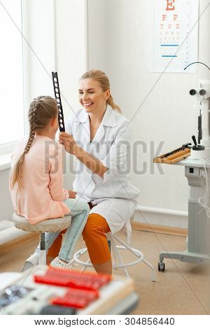 Laughing Pleasant Woman In Orange Pants Dealing With Little Kid