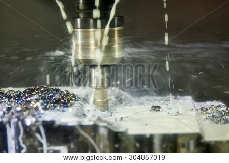 Milling machine work in metalwork industry. CNC processing detail with lubrication and coolant
