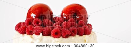 Close Up Of Red Toffee Apples And Raspberry Decoration On A Frosted Cake Against A White Background,
