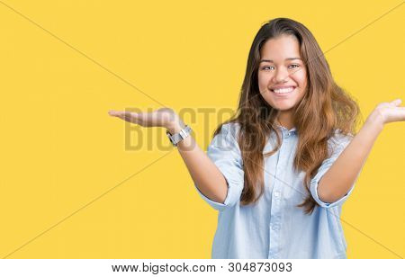 Young beautiful brunette business woman over isolated background Smiling showing both hands open palms, presenting and advertising comparison and balance