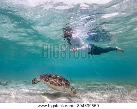 Woman On Vacations Wearing Snokeling Mask Swimming With Sea Turtle In Turquoise Blue Water Of Gili I