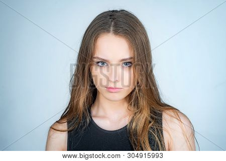 Fashion Portrait Of A Beautiful Young Woman Posing Over White Background. Close Up Portrait Of A Bea