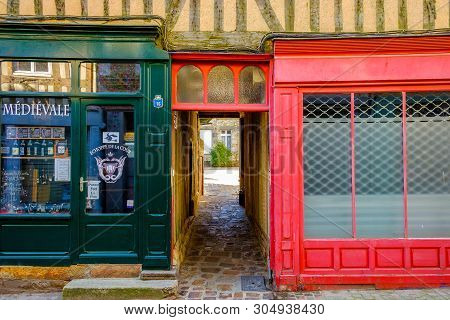 Domfront, France, Feb 2019, Alley Between Two Shops Leading To A Courtyard In A Medieval Town Of Nor
