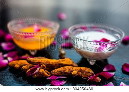 Milk Face Pack On Black Shiny Surface Consisting Of Raw Milk,turmeric Or Haldi And Badam In A Glass