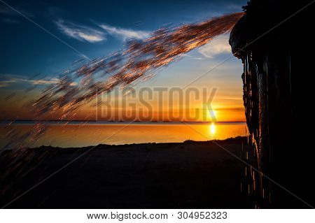 Burning Gold Splashes Against The Sunset Over The Lake