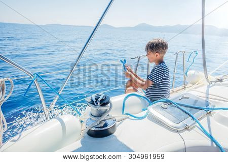 Little Boy On Board Of Sailing Yacht On Summer Cruise. Travel Adventure, Yachting With Child On Fami