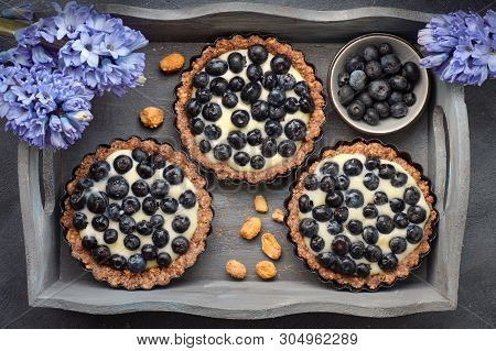 Top View On Wholegrain Blueberry Tarts With Vanilla Cream On Dark Background