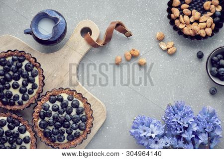 Top View On Wholegrain Blueberry Tarts With Vanilla Cream On Light Textured Background