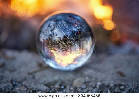 Upside Down View Through The Lensball On Blurred Campfire In Forest