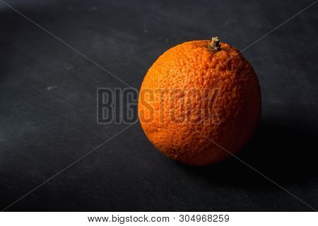 Isolated Orange With Dramatic Lighting On Dirty Chalkboard Background