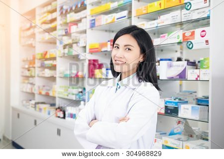 Beautiful Smiling Young Woman Pharmacist Doing His Work In Pharmacy.