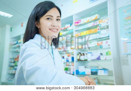 Beautiful Smiling Young Woman Pharmacist Doing His Work In Pharmacy.