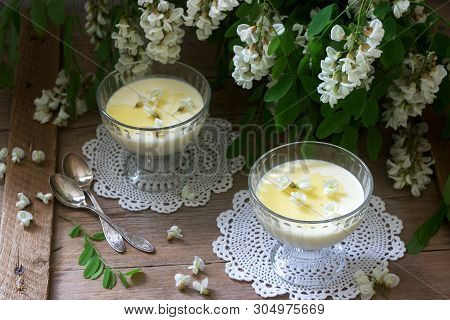 Panna Cotta With Robinia Flavor, Served With Honey And White Robinia Flowers. Rustic Style.
