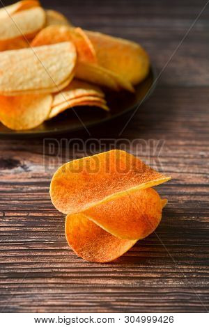 Potato Chips Over Wooden Background. Salty Crispy Snack. Isolated Chips.