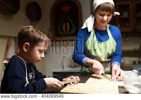 Mother And Son Cutting Dough Into Strips For Cooking Chak-chak In Kitchen
