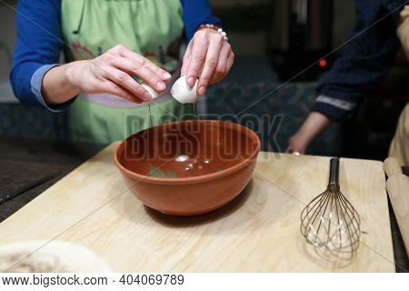 Woman Breaking Eggs To Make Dough