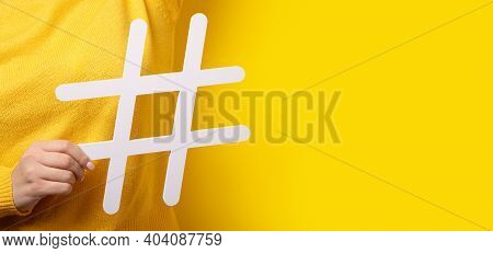 Social Media Concept, Closeup Of Human Hand Holding And Showing Large Big White Hashtag Sign