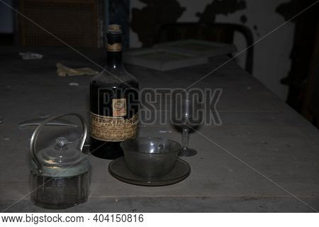 Italy, January 20, 2021. Bottle Of Liquor And Glasses In An Abandoned House. Urbex