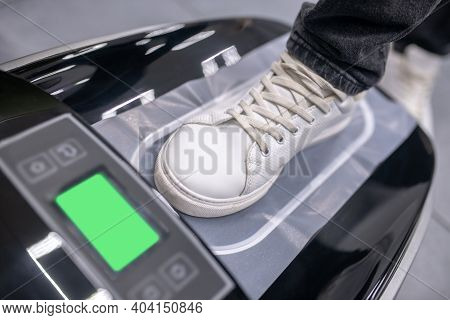 Foot In Sneaker On Electronic Device With Thermal Film